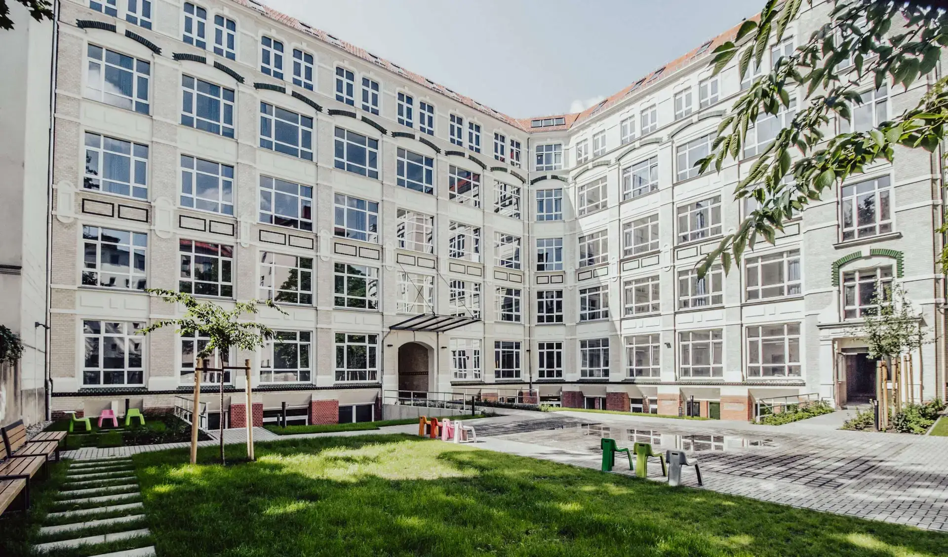 Innenhof mit großer Fensterfront, die von der Sonne angeleuchtet wird