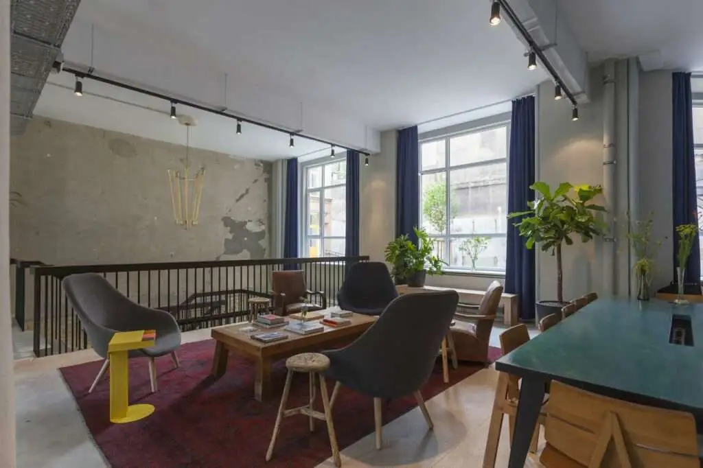 Lounge- und Essbereich mit gedeckten Farben und großen Fenstern