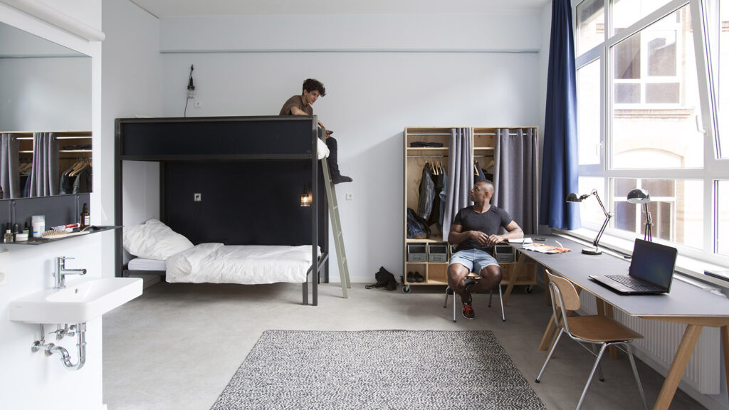 Zimmer mit Doppelstockbett, zwei Schreibtischen und einem Schrank
