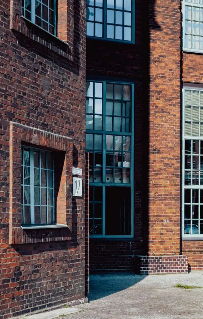 Ecke eines Backsteingebäudes mit großen verstrebten Fenstern