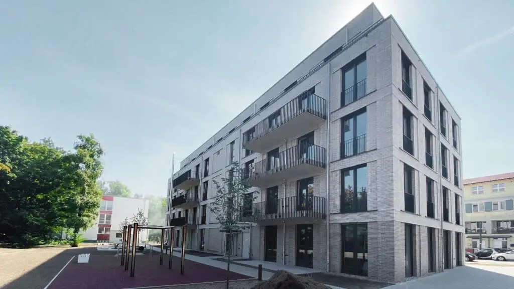 Neubau mit vielen Wohnungen, einem Hinterhof und schwarzen Elementen