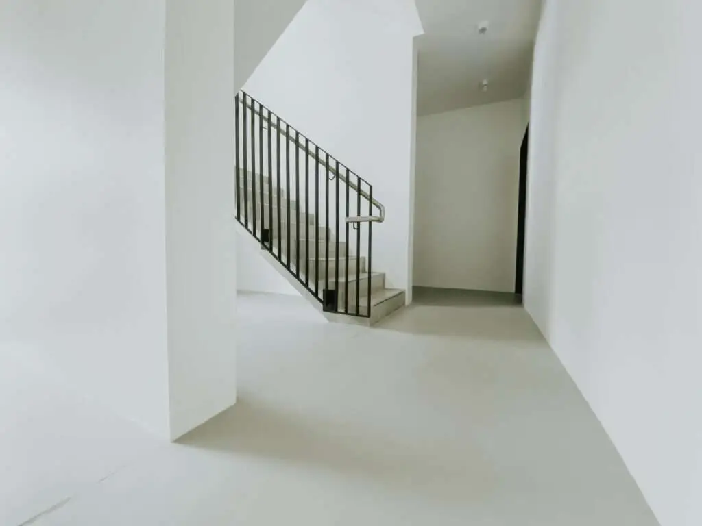 weiß gehaltenes Treppenhaus mit schwarzen Elementen