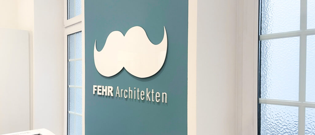 FEHR Architekten Logo an der türkiesen Wand im Büro