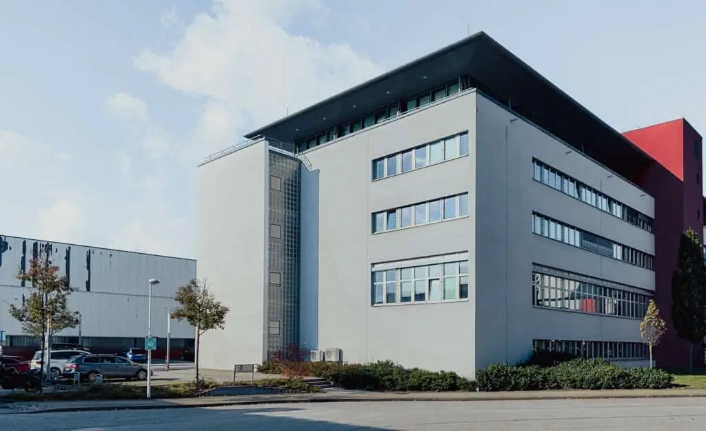 Bürogebäude mit grauer Fassade und einer Straße im Vordergrund