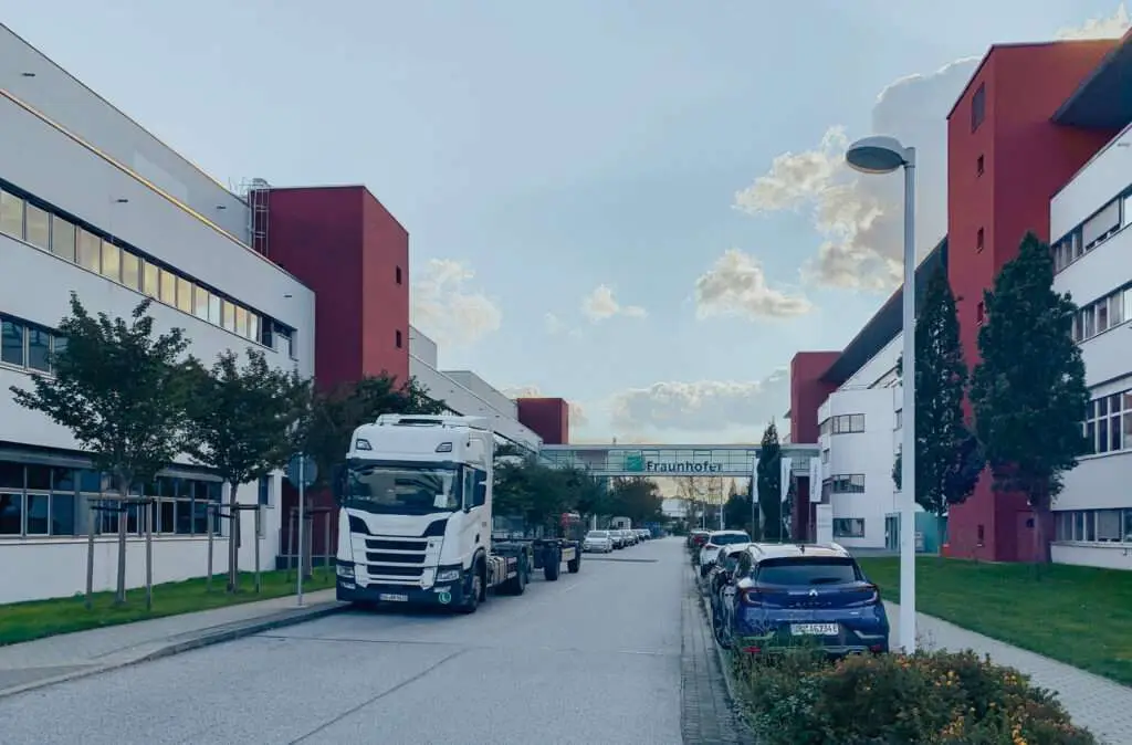 Straße mit rot-weißem Gebäude auf beiden Seiten und einem LKW in der Mitte