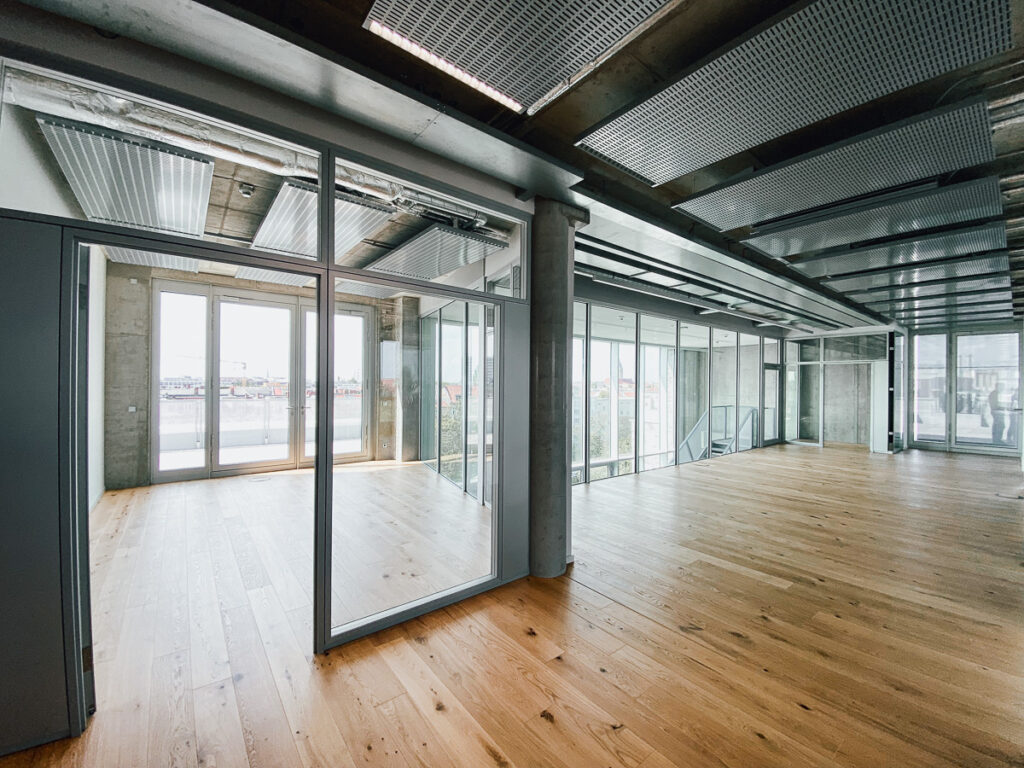 Coworkingflächen mit Holzboden und viel Glas